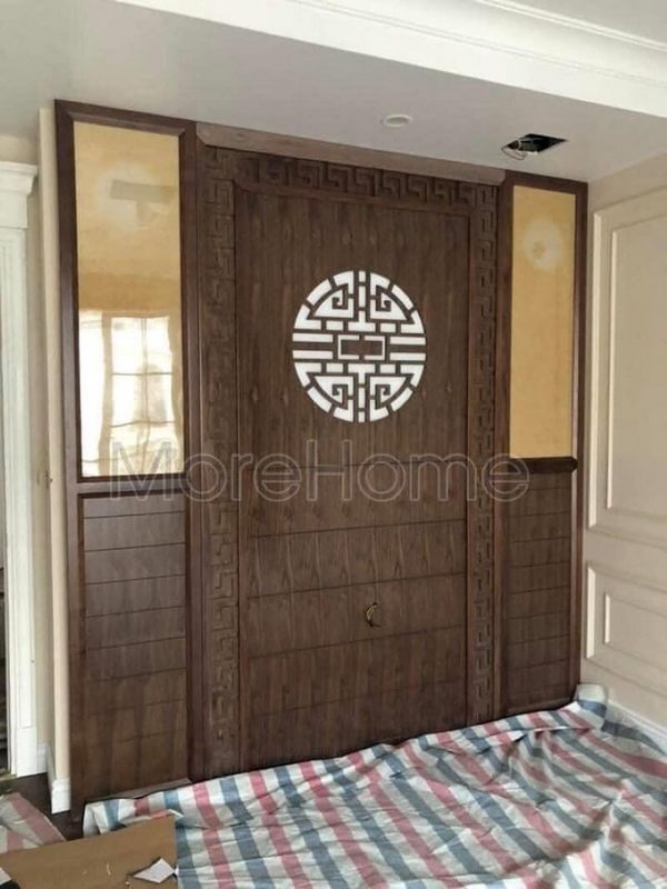 Mẫu vách ốp tường phòng thờ gỗ óc chó được nhiều khách hàng quan tâm với màu sắc sang trọng, kết hợp tranh kính tôn lên vẻ trang nghiêm của phòng thờ.